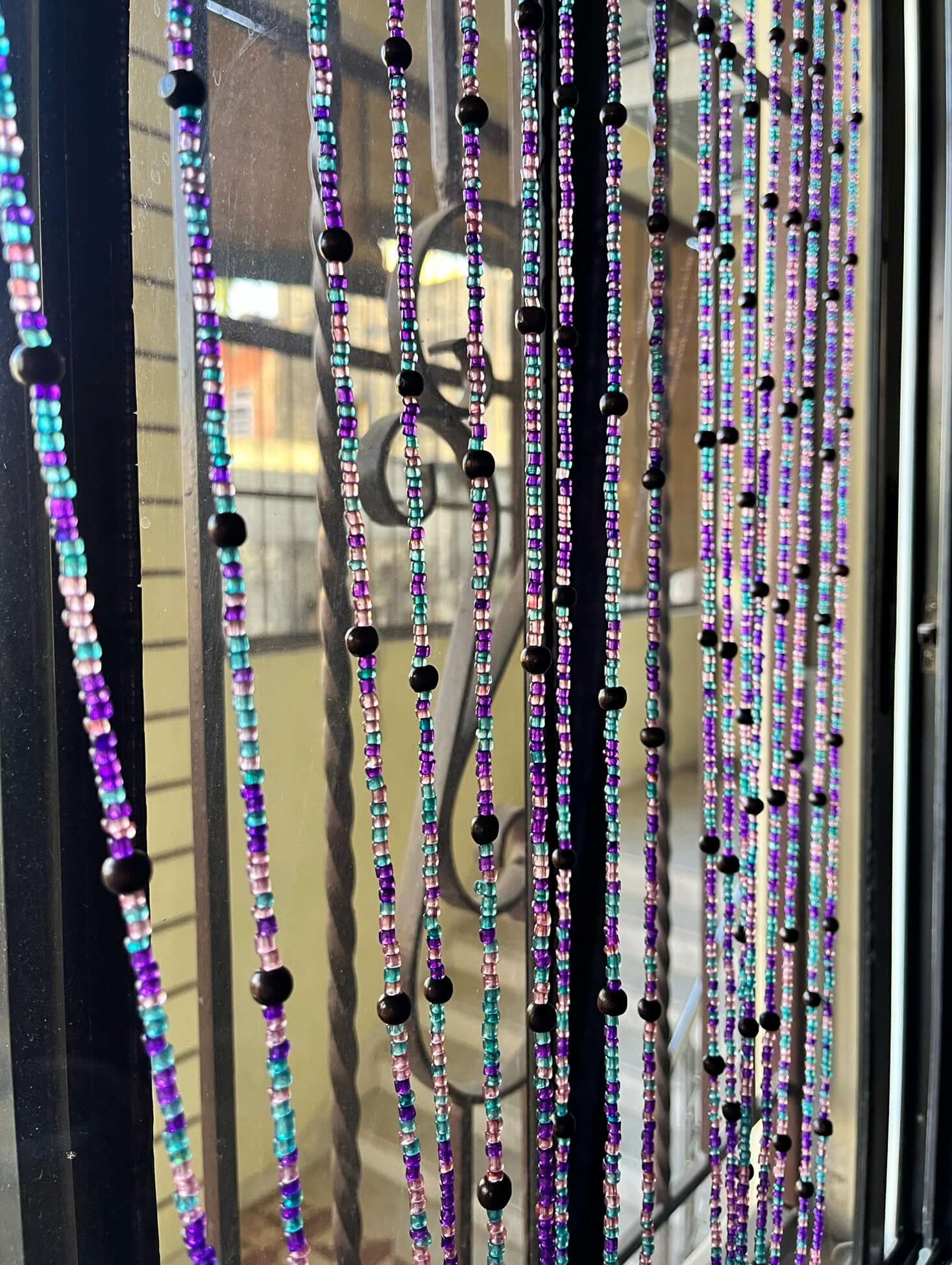 Handmade colorful glass bead strands with jingle bells—perfect for doorways or wall décor. Eco-friendly and crafted by women's artisans in India.